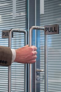 close up of a hand pulling open an office door